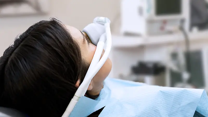 Patient with sedation mask on and eyes closed