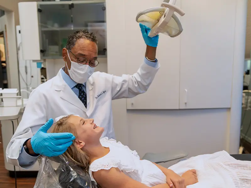 Orthodontist pulling light closer to examine patient